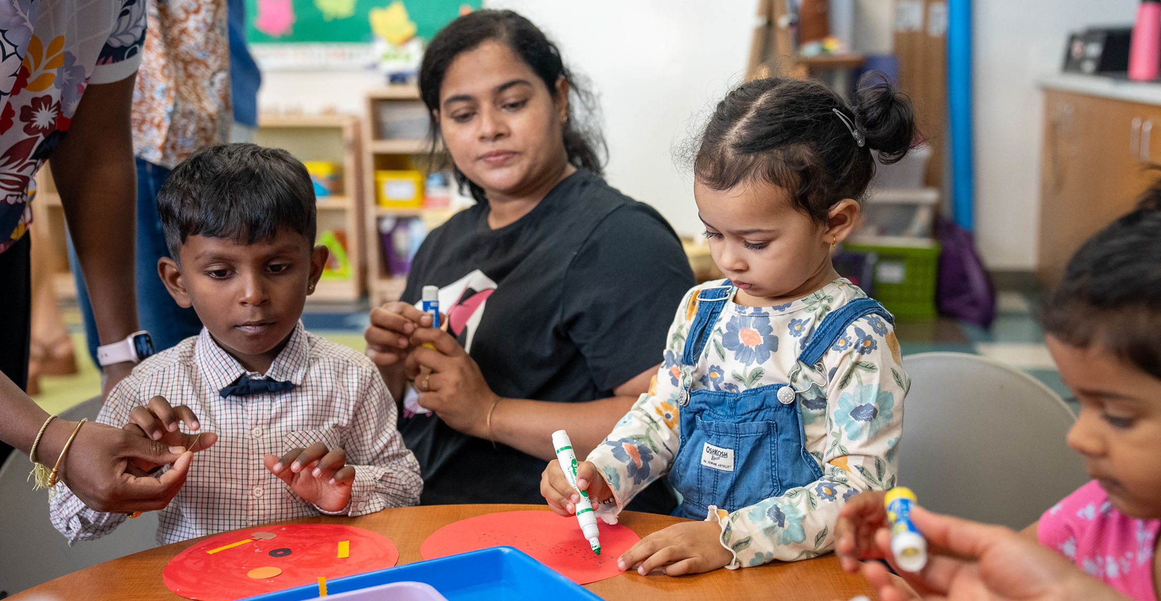 Child development student with children doing crafts