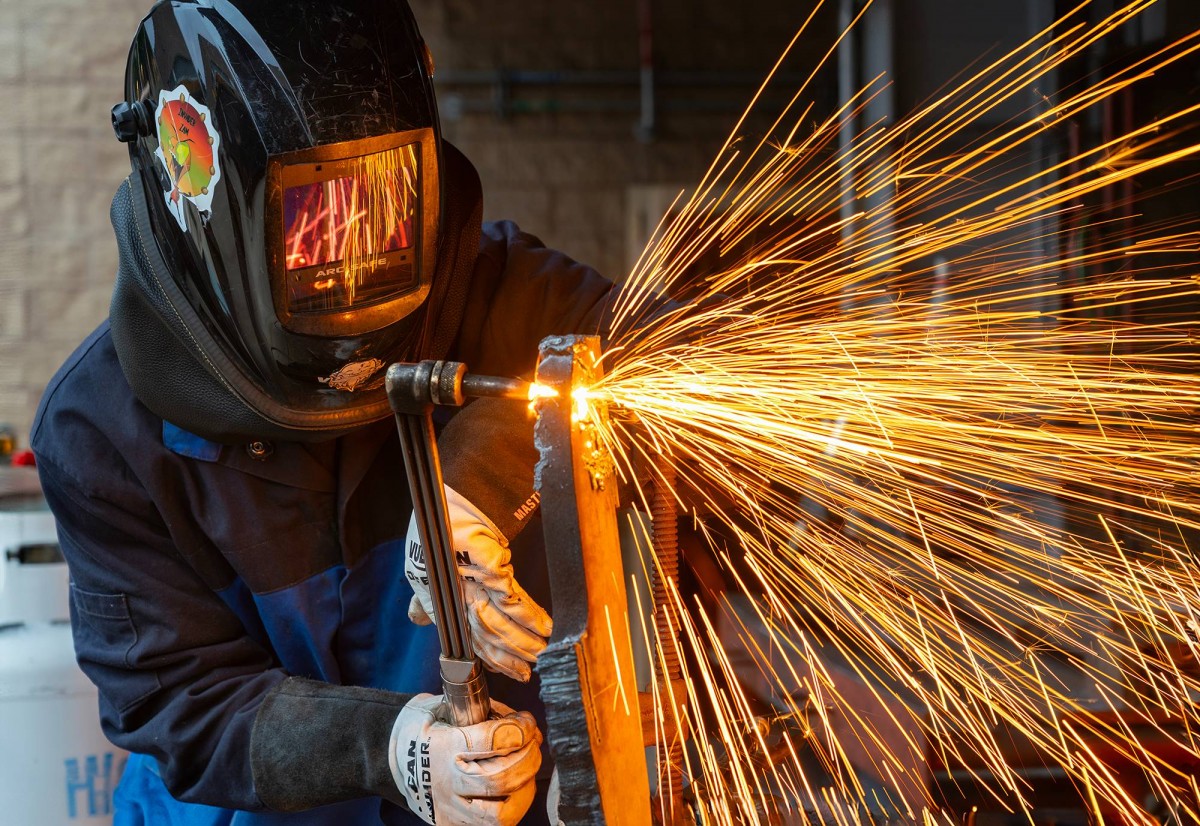 Student welder Nathan Torres working on a project in the welding facility at the Educational Cultural Complex. 